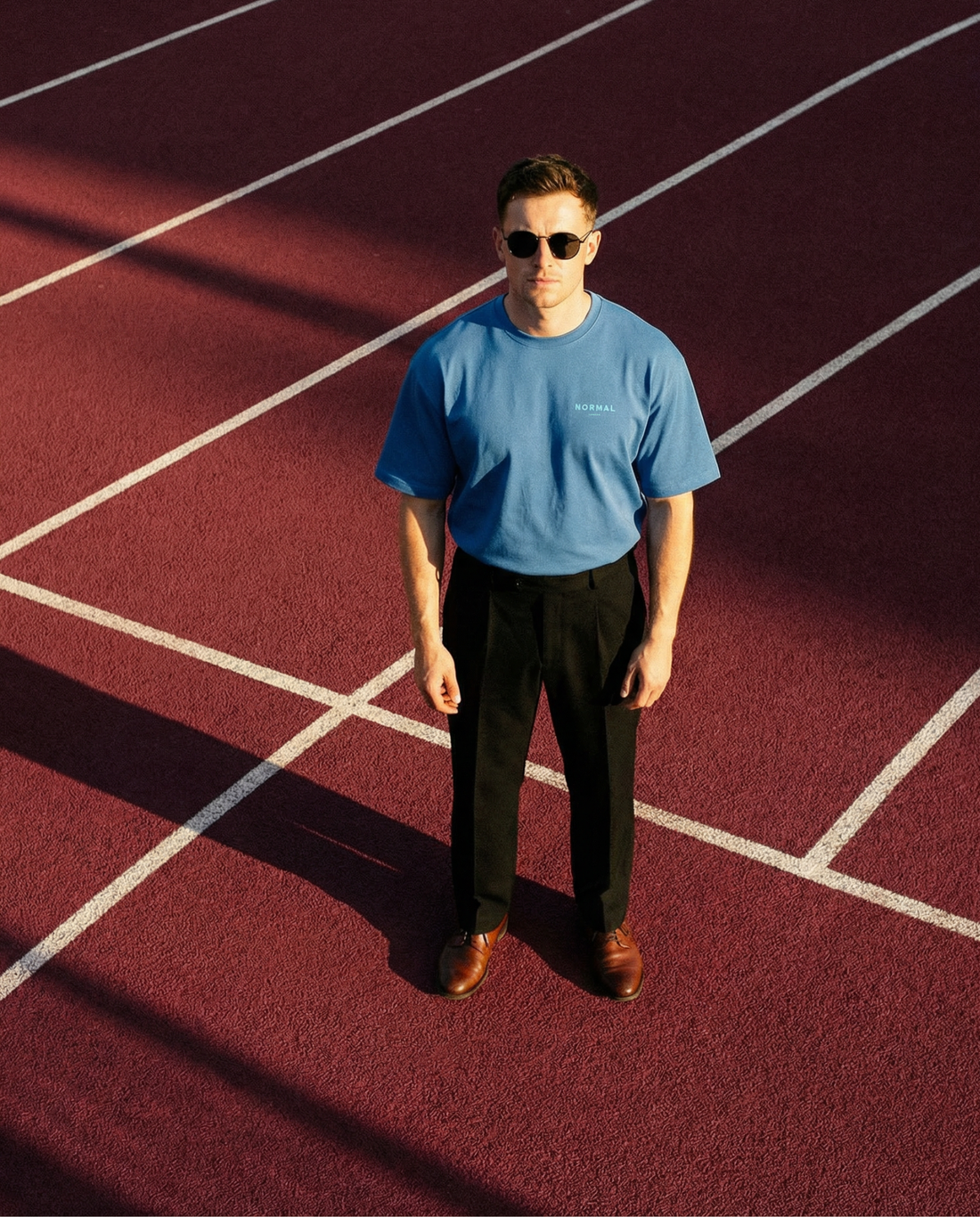 Male model wearing normal standard club oversize standard t-shirt posing on the running track