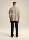 Model wearing Brenton Showcasing the back of the T-shirt with the word NORMAL print across the t-shirt.
