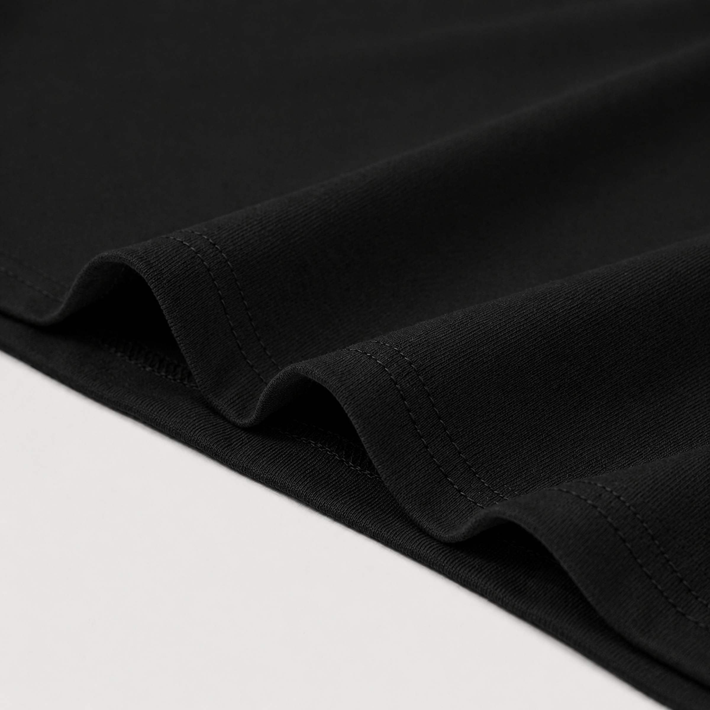 Close-up of black fabric bottom edge on a white background