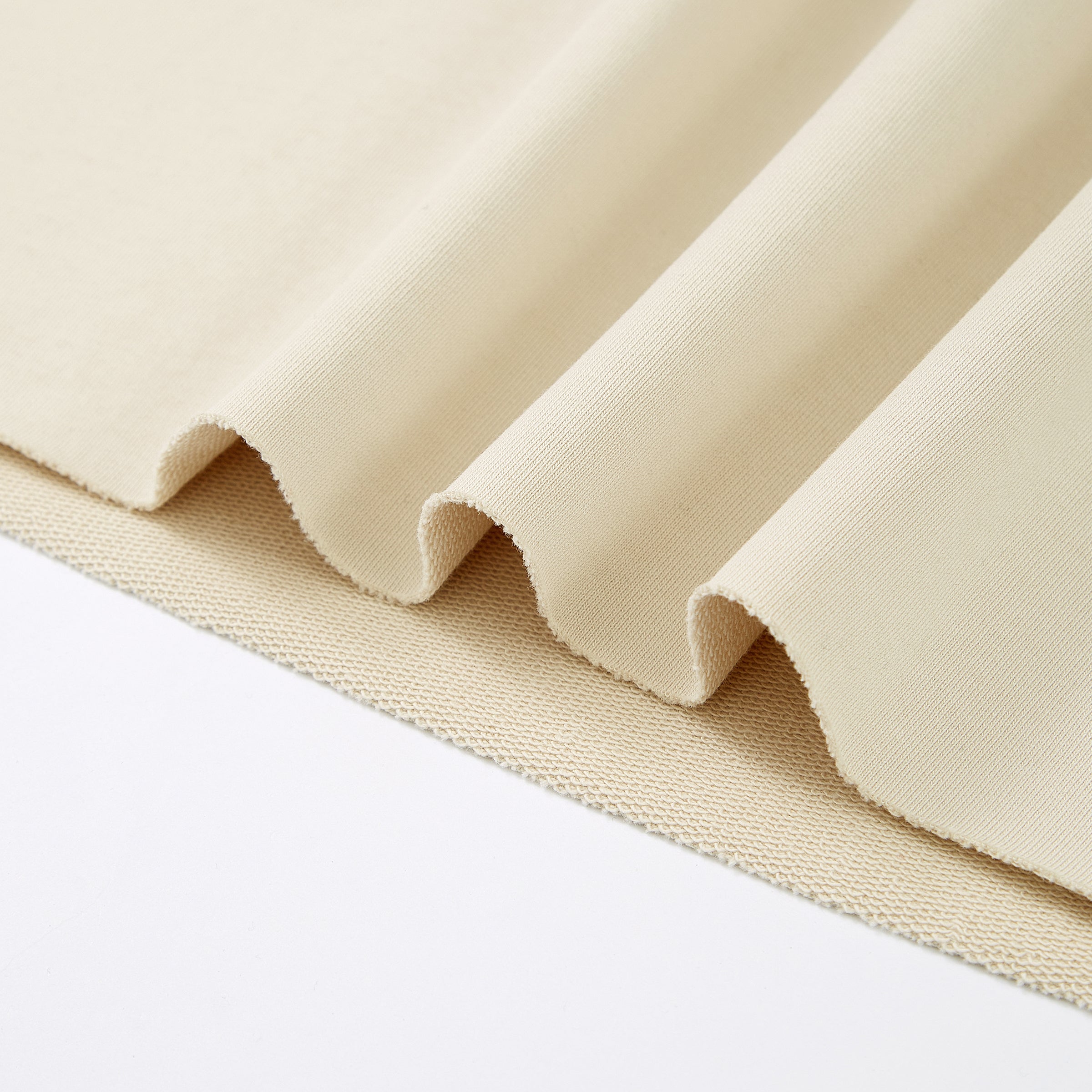 Close-up of beige fabric with a textured pattern on a white background